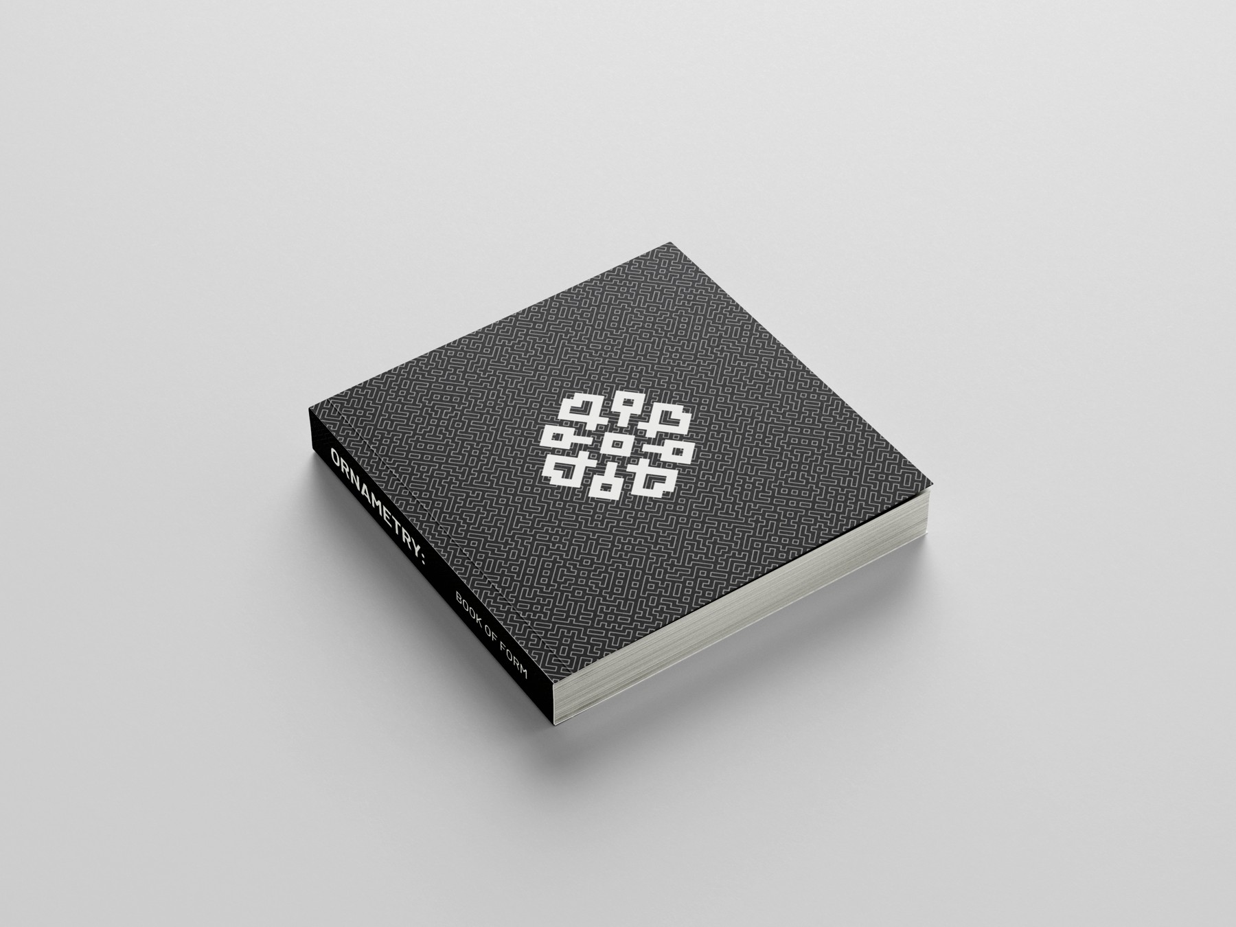 Angled view of Ornametry’s black patterned cover and white geometric ornament