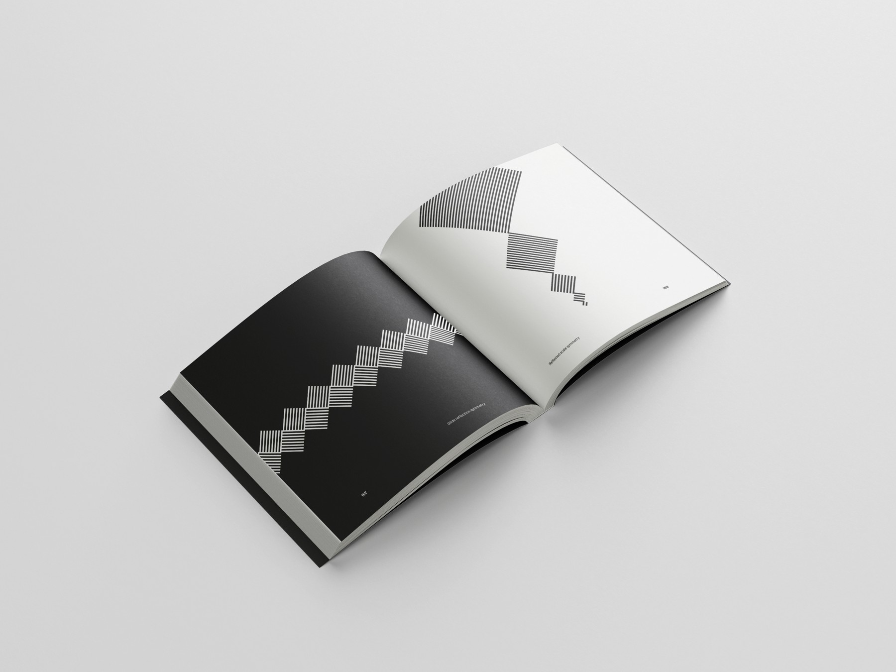 A stepped geometric form crossing a black and white spread